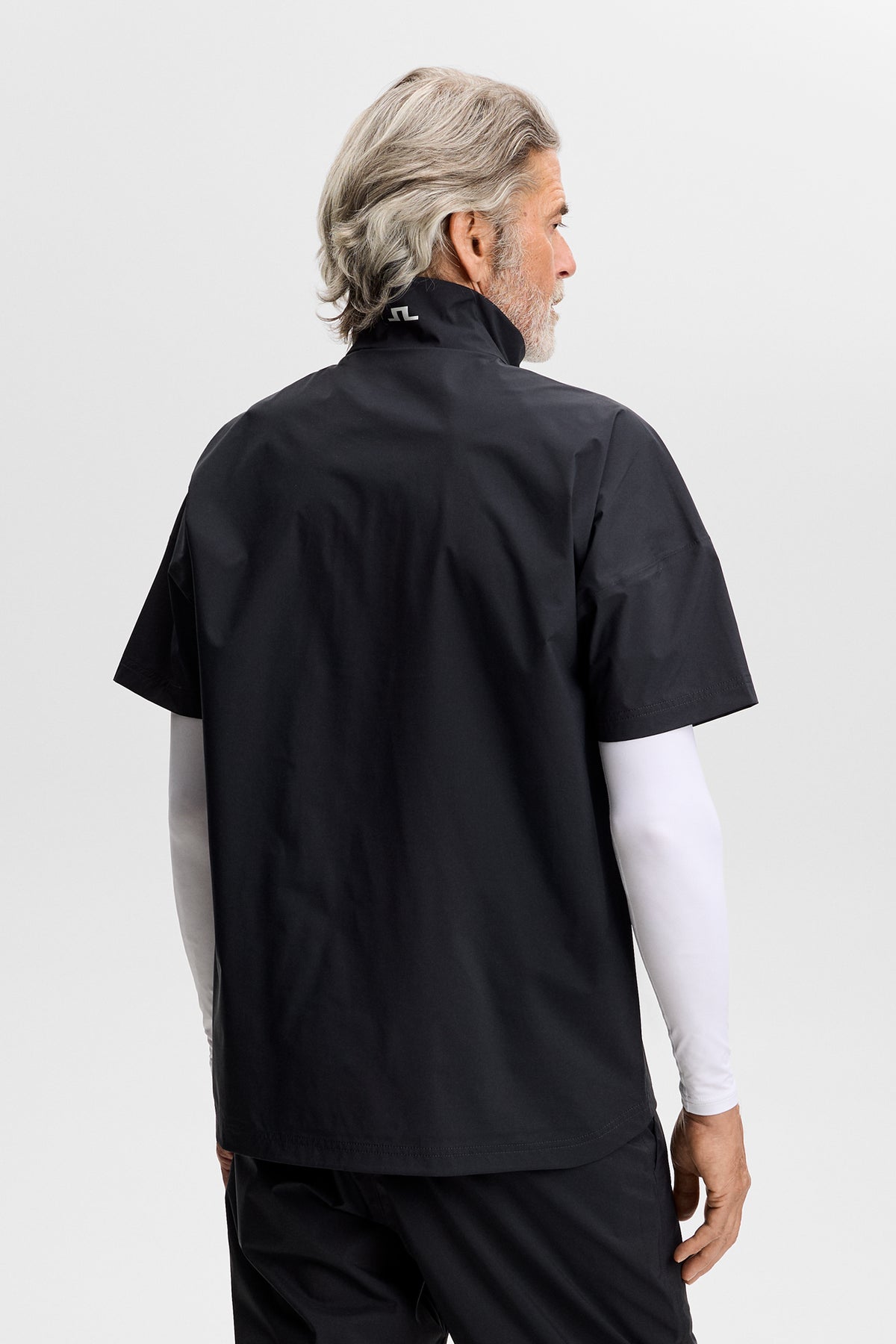 J.Lindeberg Shay Rain Shirt Black – Seitenansicht mit stromlinienförmiger Silhouette und Branding